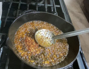 adding black pepper and red chilli flakes to honey chilli chicken|kothiyavunu.com